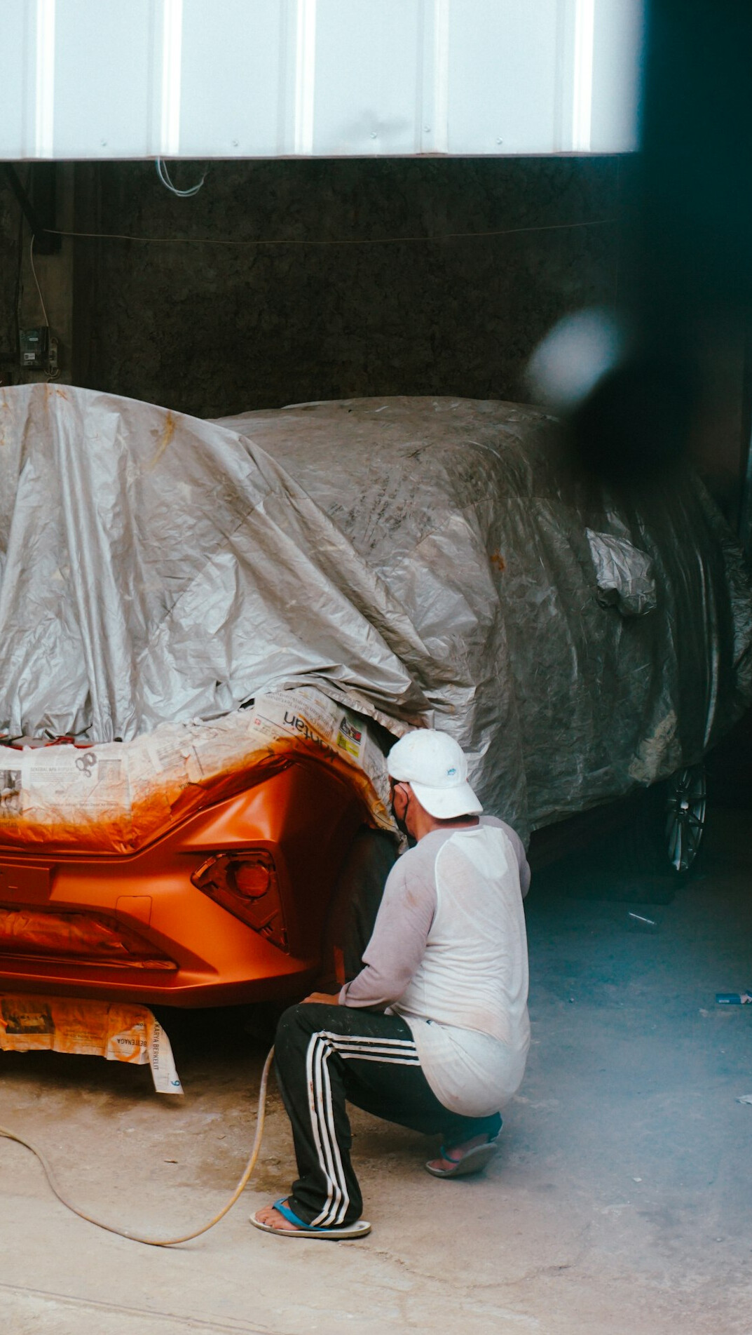 Bright car body workshop with a car on a lift