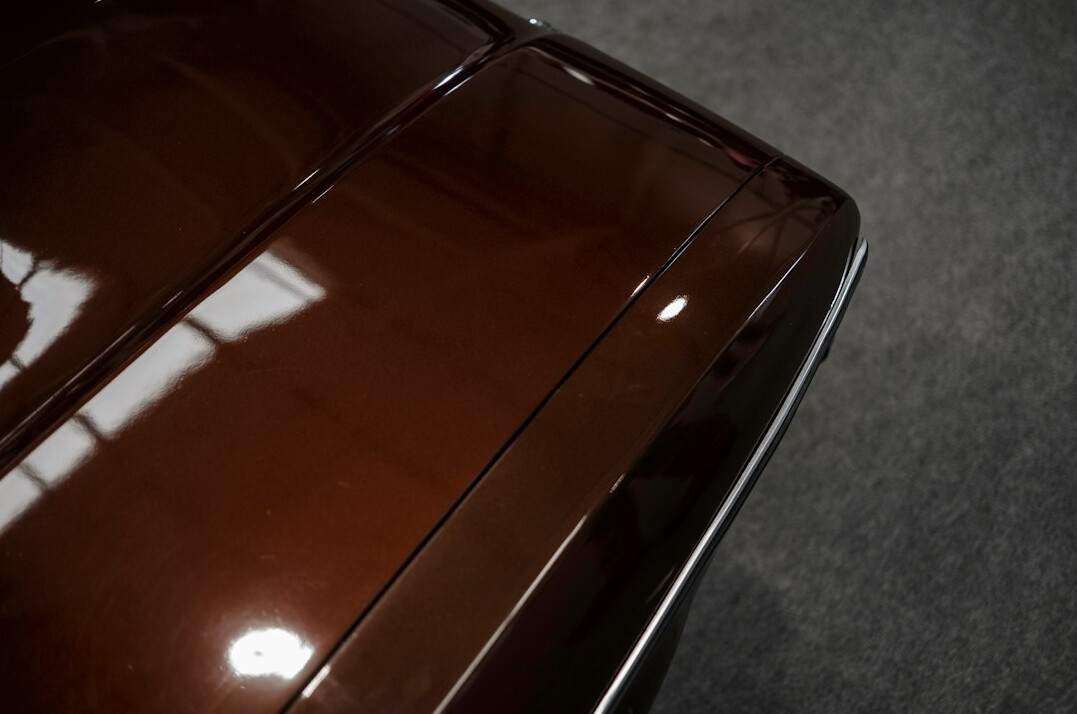 Close-up of a polished car hood with reflections