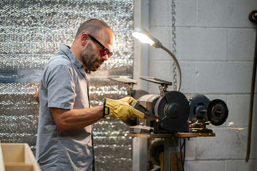 Auto body technician polishing a car panel in a workshop